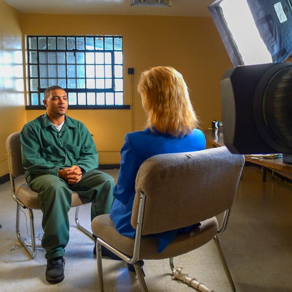 Sarah Wallace conducting an on-camera interview in a secured room.